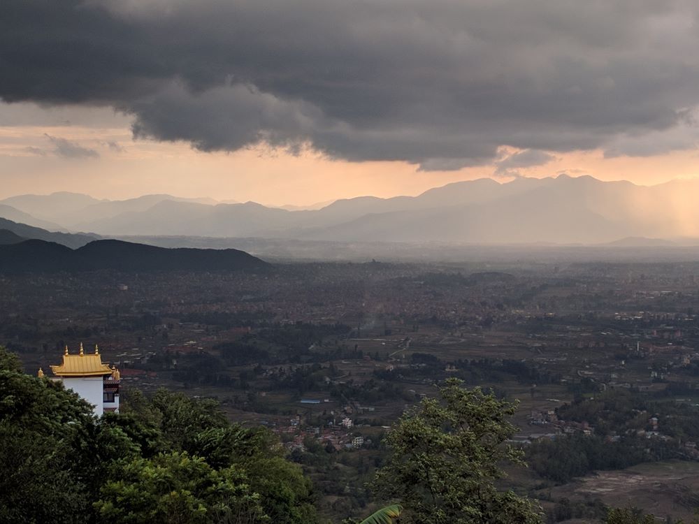 Panoramic view of Kathmandu Valley with prayer flags, hinting at cultural treks